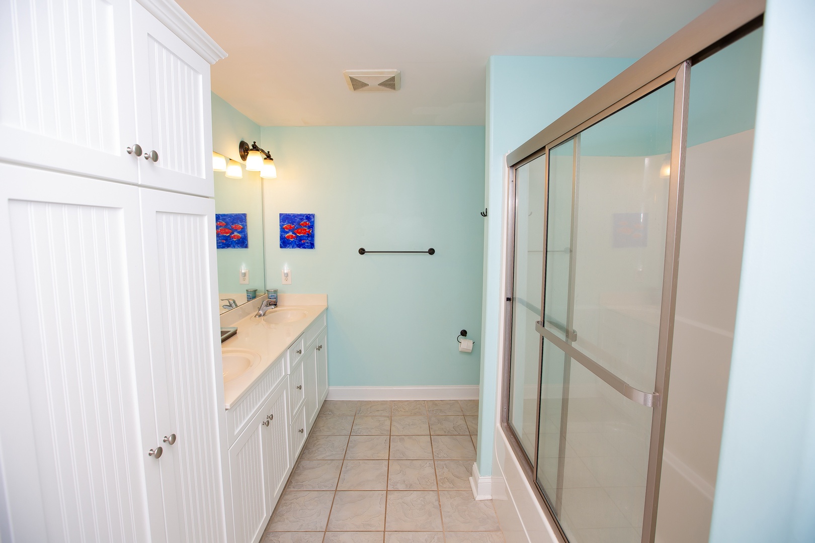 Refresh in your private bathroom featuring spacious vanity, glass shower, and coastal-inspired decor that sets a peaceful tone.