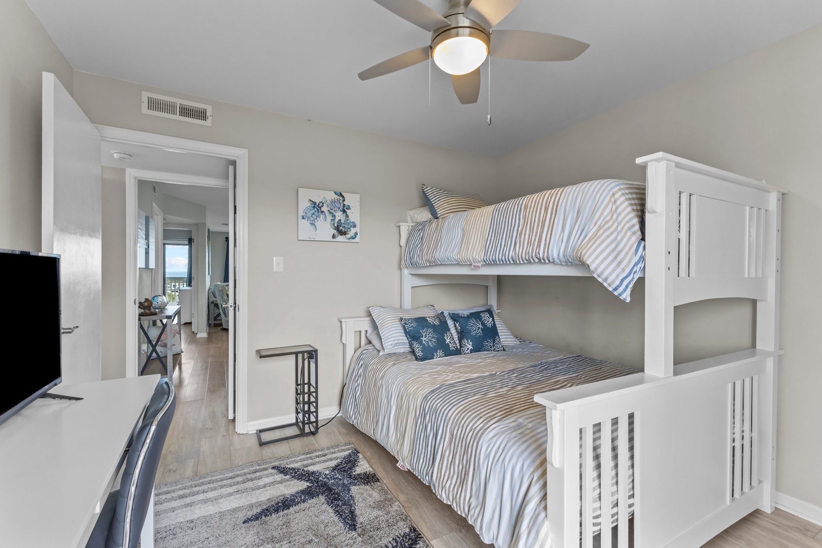 Your cozy bunk room features crisp white beds with nautical linens and a ceiling fan for comfort.