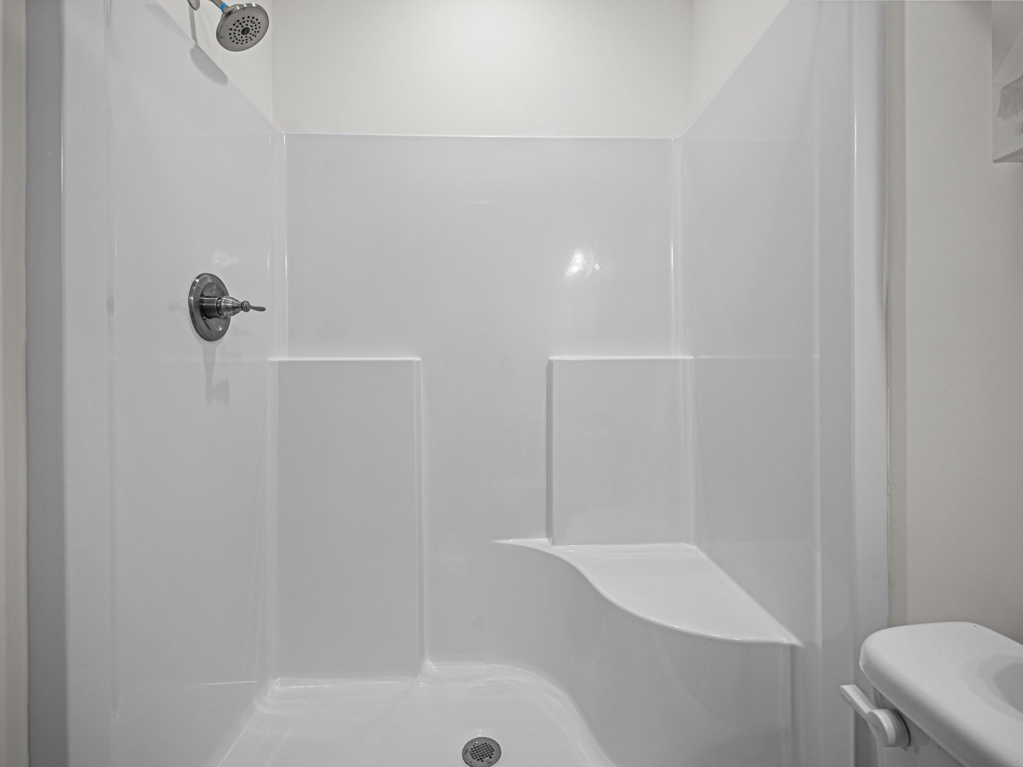 Step into your private shower sanctuary with pristine white walls and modern fixtures for a refreshing start to each day.