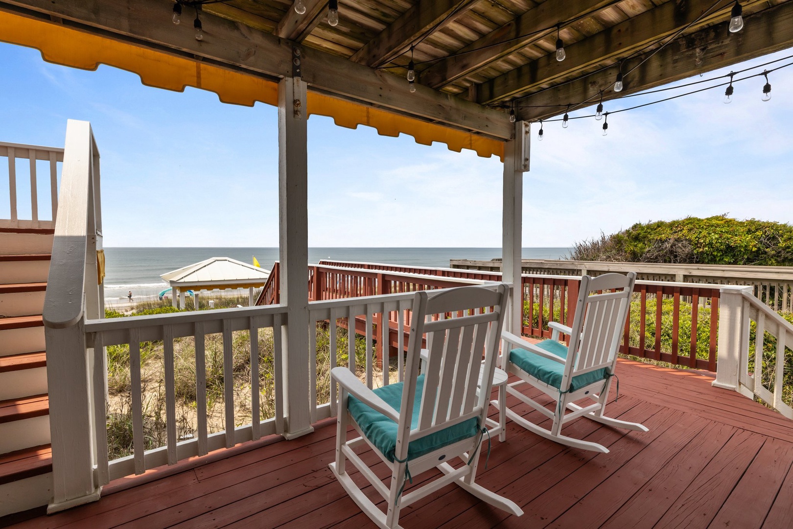 Unwind in your ocean-view rocking chairs on this covered deck, where turquoise cushions invite you to relax while gentle sea breezes carry the sound of waves.