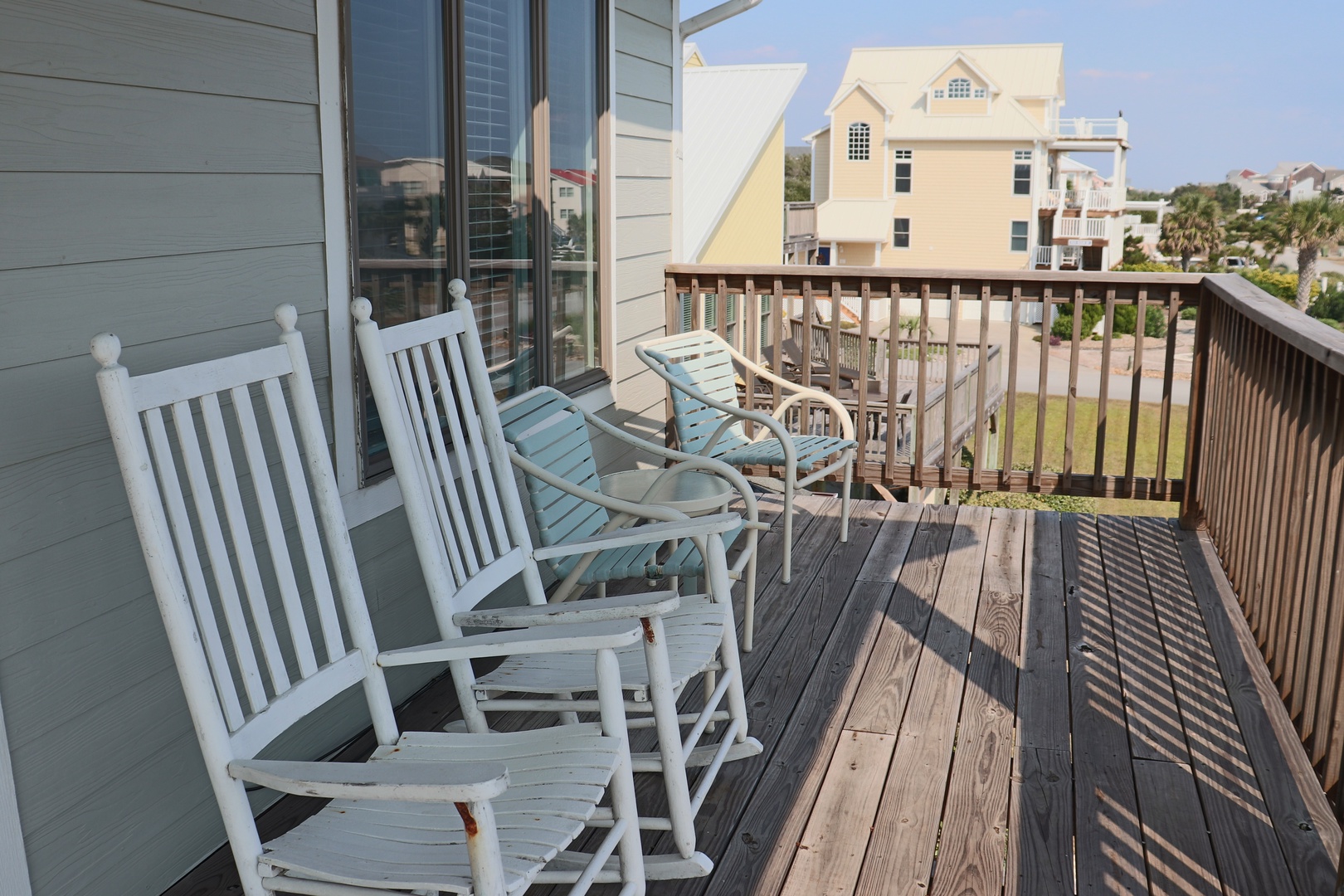 Unwind on your private balcony with comfortable rocking chairs, perfect for morning coffee and watching neighborhood life below.