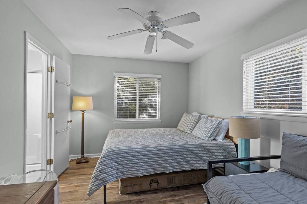 Your peaceful bedroom features soft lighting, a ceiling fan for comfort, and natural light filtering through the blinds.