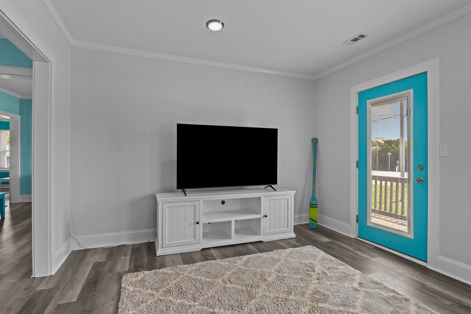 Cozy up in your bright living space with modern TV entertainment and cheerful turquoise accents throughout.