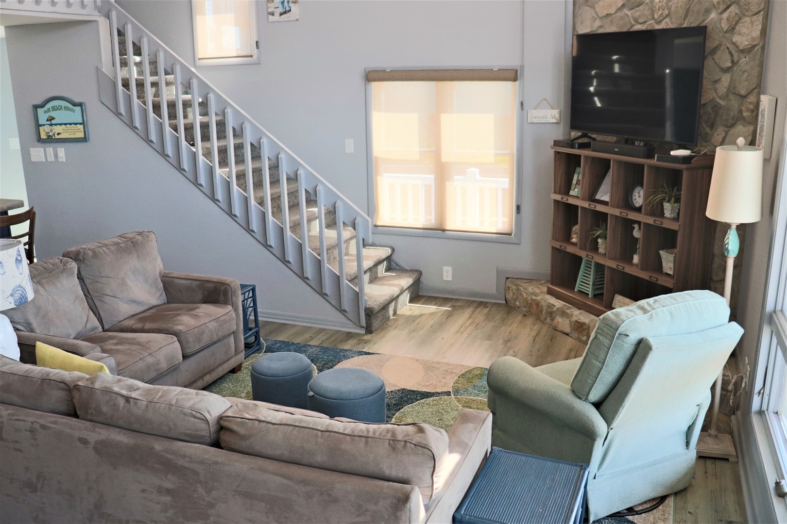 Unwind in your spacious living room with plush seating, entertainment center, and natural light streaming through large windows.