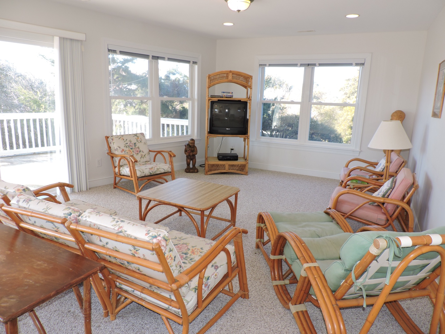 Unwind in your bright living room with comfortable bamboo furniture and peaceful garden views through large windows.