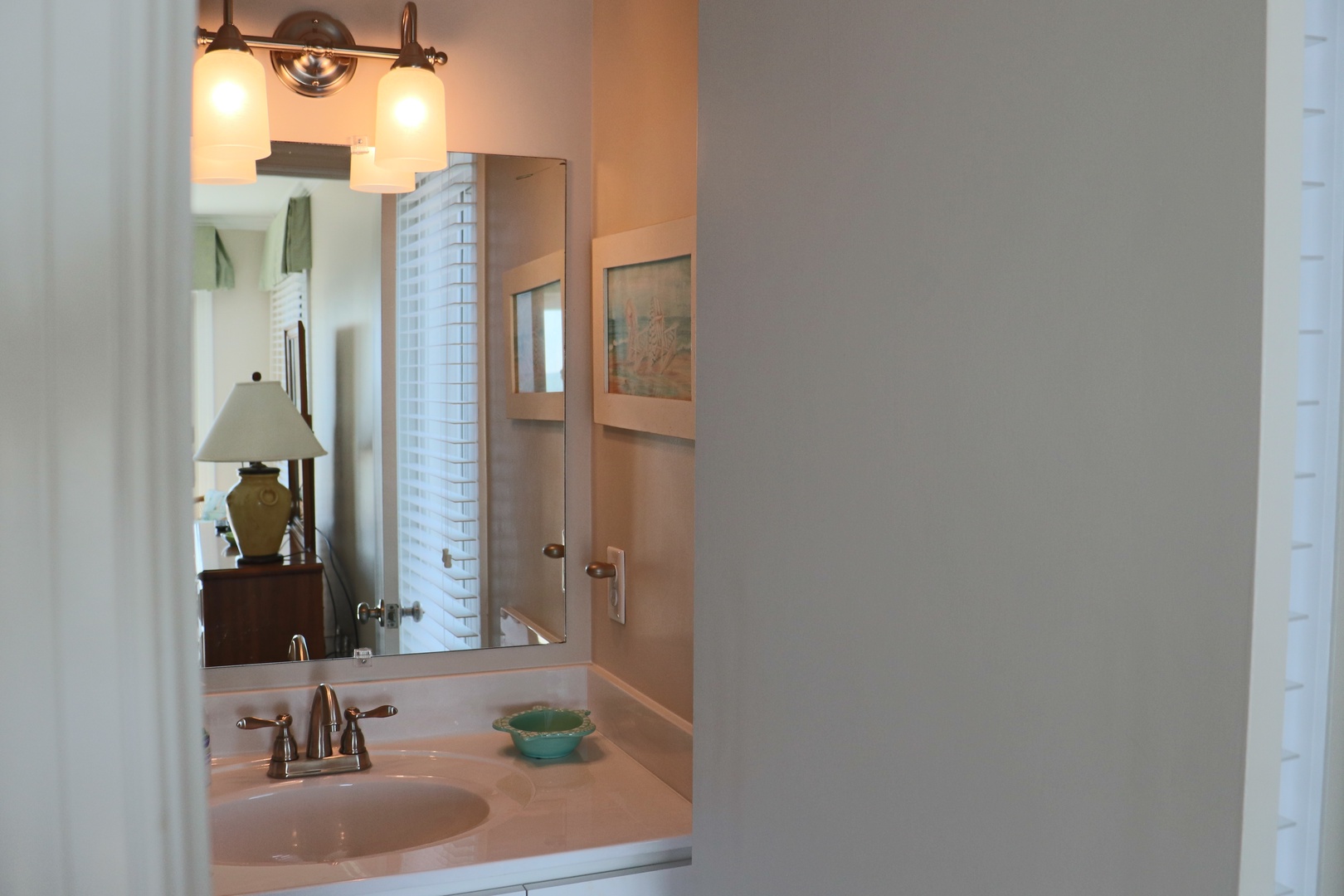 Step into your elegantly appointed bathroom, where warm lighting and thoughtful details create a serene retreat for your daily routines.