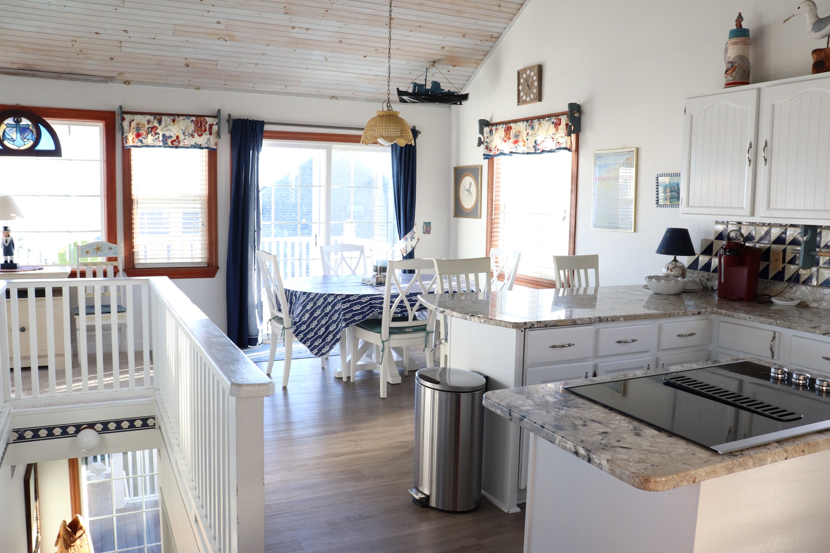 Enjoy your meals in this bright kitchen with granite countertops, nautical accents, and sunny dining space overlooking the deck.