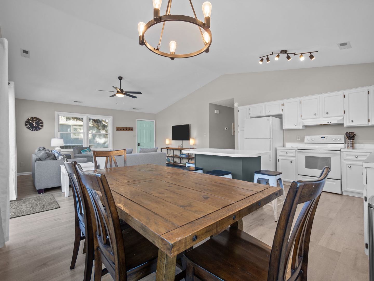 Your spacious open-concept home flows seamlessly from kitchen to dining to living, perfect for gathering with loved ones under elegant lighting.