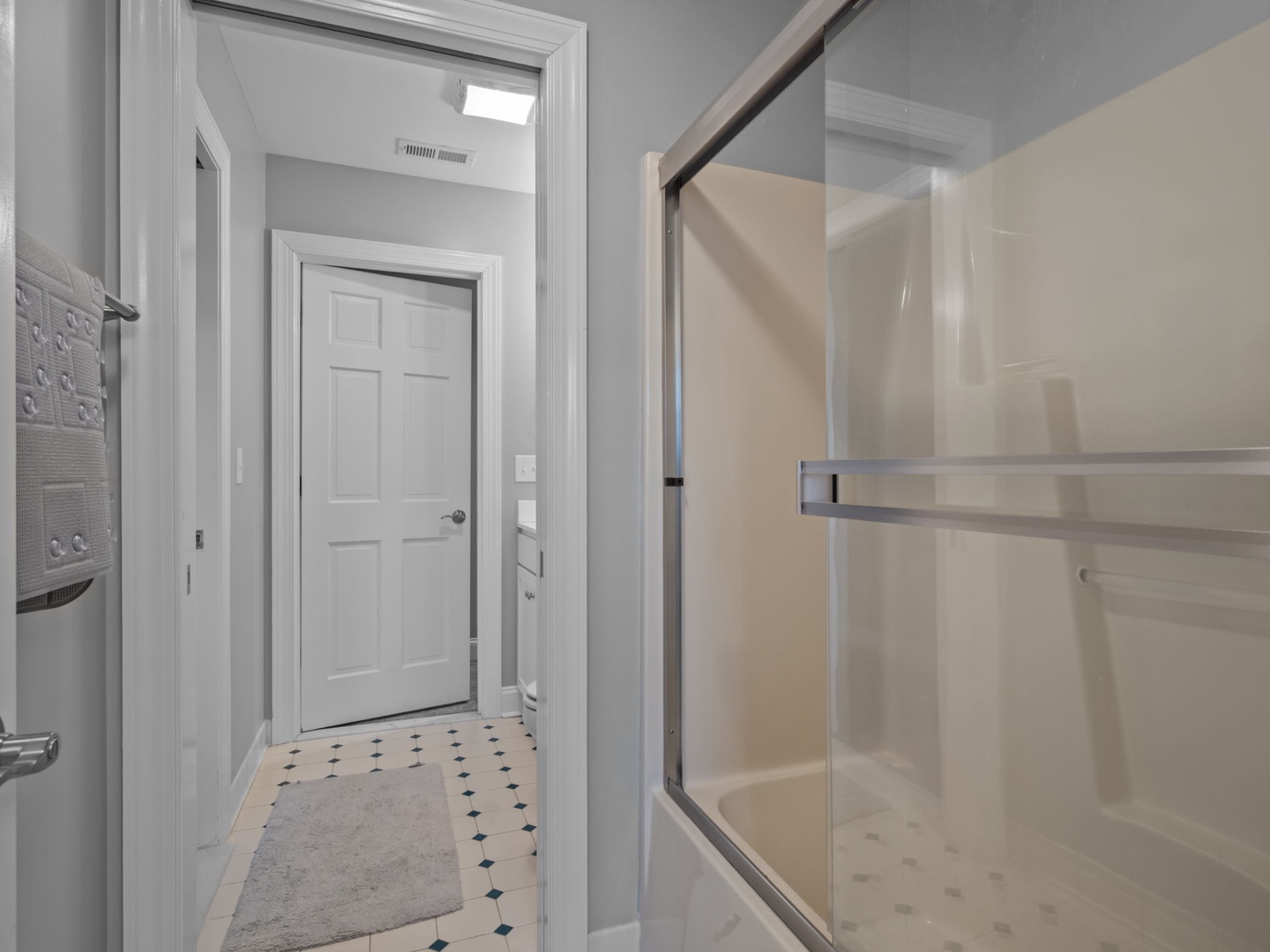 Step into your pristine bathroom featuring a spacious glass-enclosed shower with modern fixtures and elegant tile flooring.