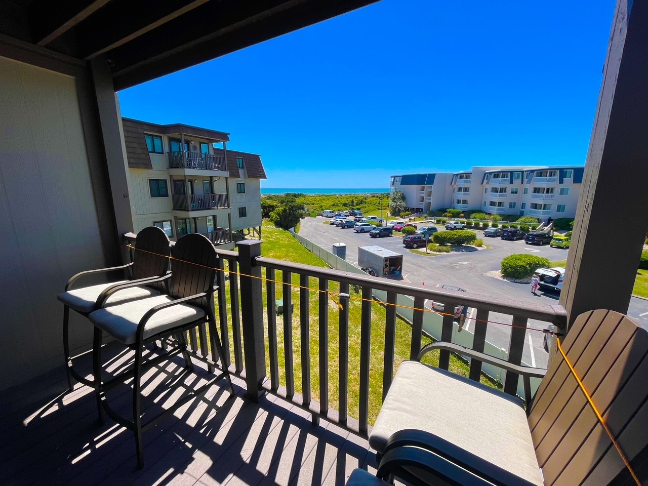 Your private balcony offers stunning ocean glimpses beyond peaceful grounds, with comfortable seating perfect for morning coffee or sunset drinks.