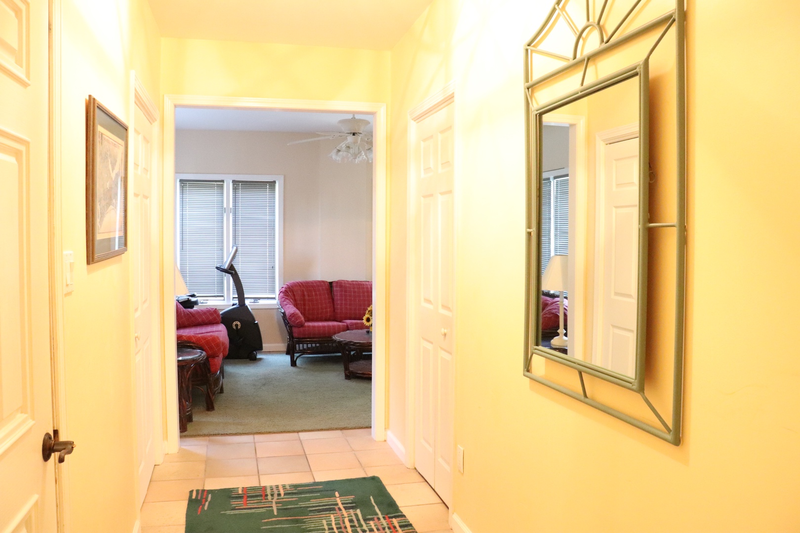 Step into your welcoming hallway where warm yellow walls and thoughtful touches create an inviting entrance to your comfortable living space.