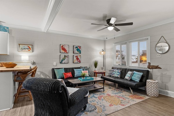 Step into your stylish living space where modern comfort meets vibrant charm. Relax on the sleek sofa while the ceiling fan keeps you cool.