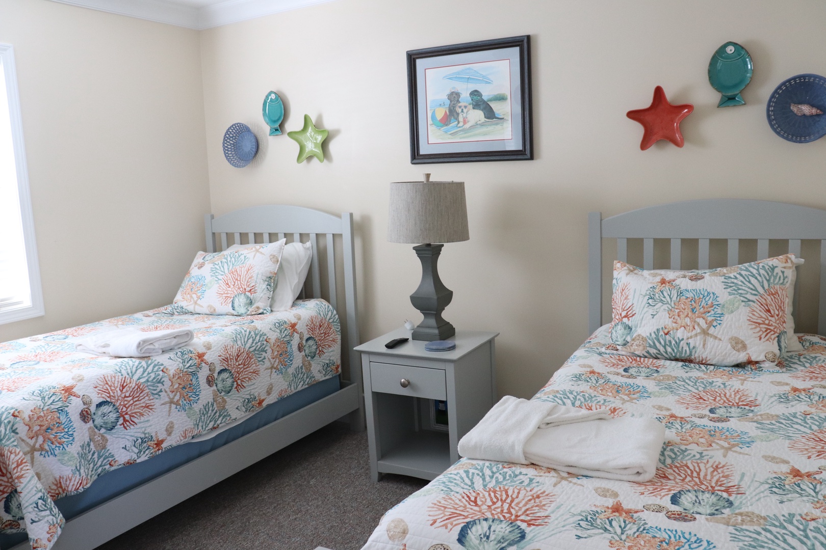Drift off in twin beds with coral reef linens, sharing coastal dreams in this charming beach-themed bedroom.
