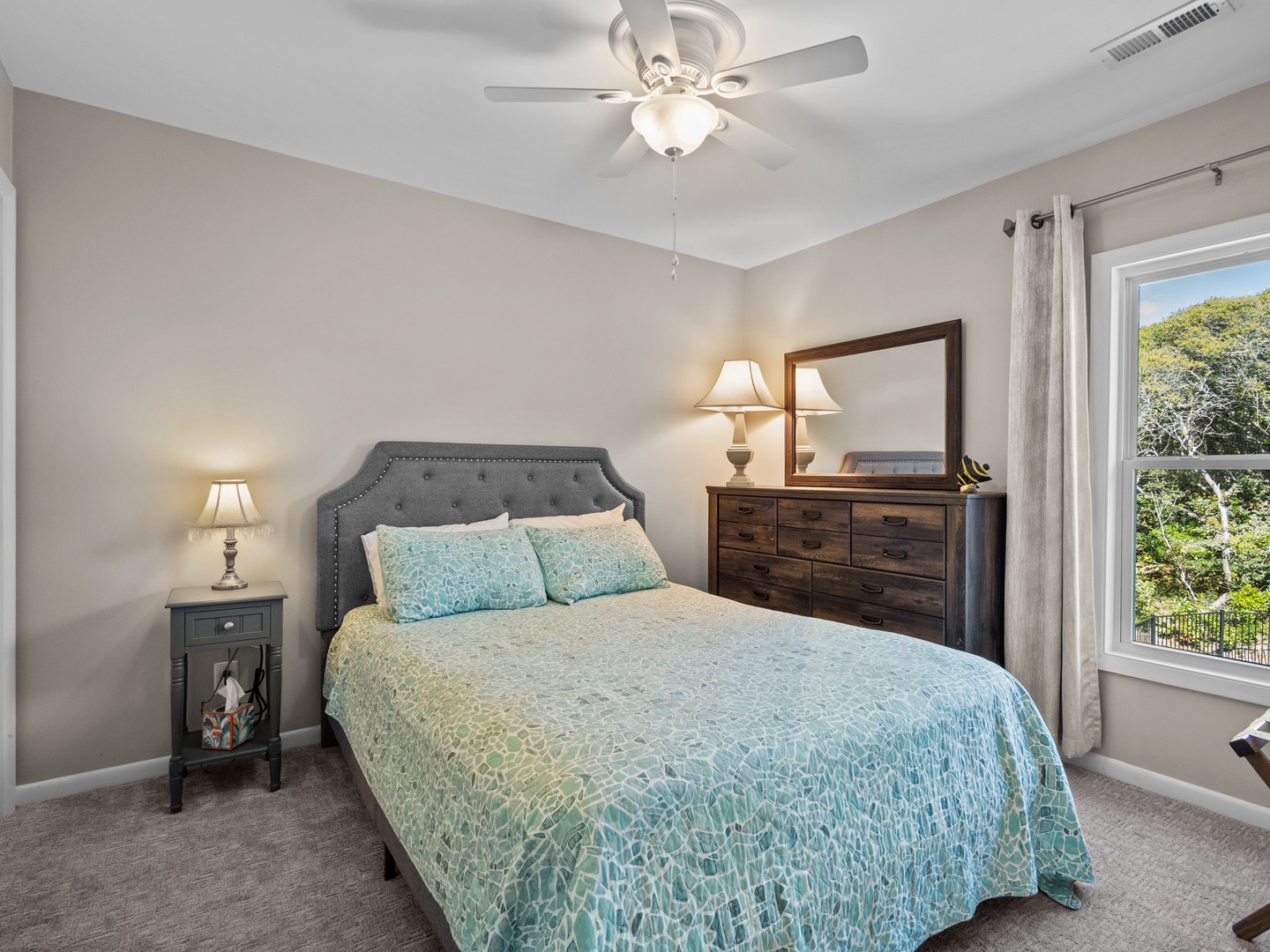 Relax in your peaceful bedroom with soothing aqua linens, elegant furnishings, and gentle ceiling fan breezes to lull you to sleep.