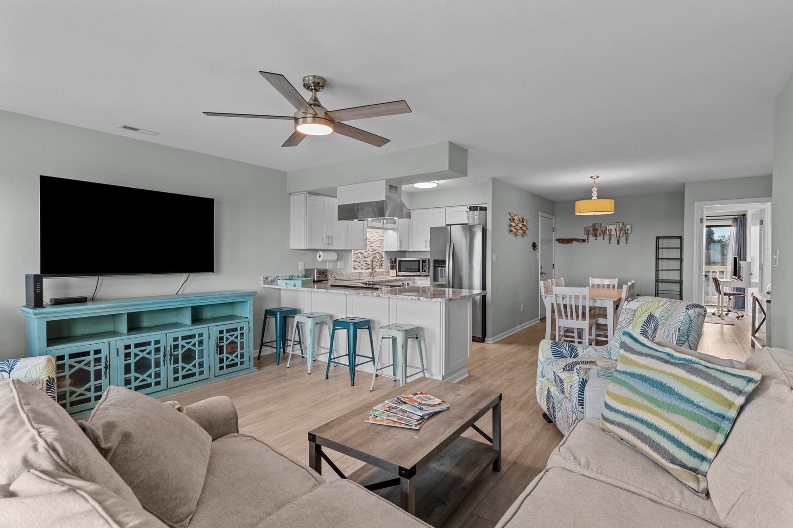 Unwind in your open-concept living space where coastal colors meet modern comfort—perfect for relaxing after beach days.