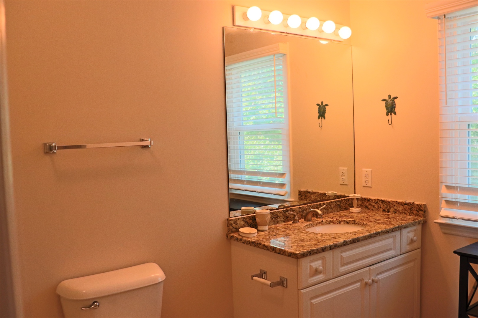 Freshen up in your private bathroom featuring warm lighting and granite vanity for your daily routines.