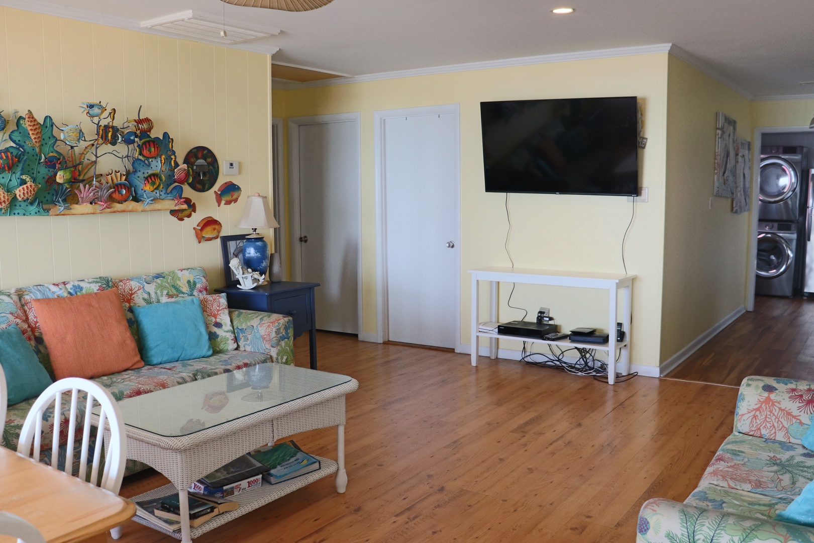 Your bright living space features tropical-themed decor, comfortable seating, and entertainment amenities for relaxing after your beach adventures.