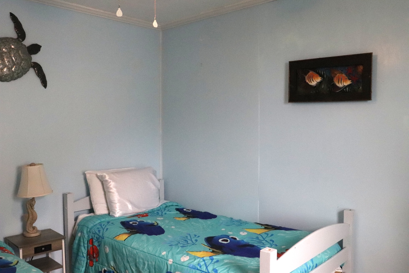 Drift off in your ocean-themed bedroom, where playful sea turtle decor and coastal touches create a soothing seaside escape for your getaway.