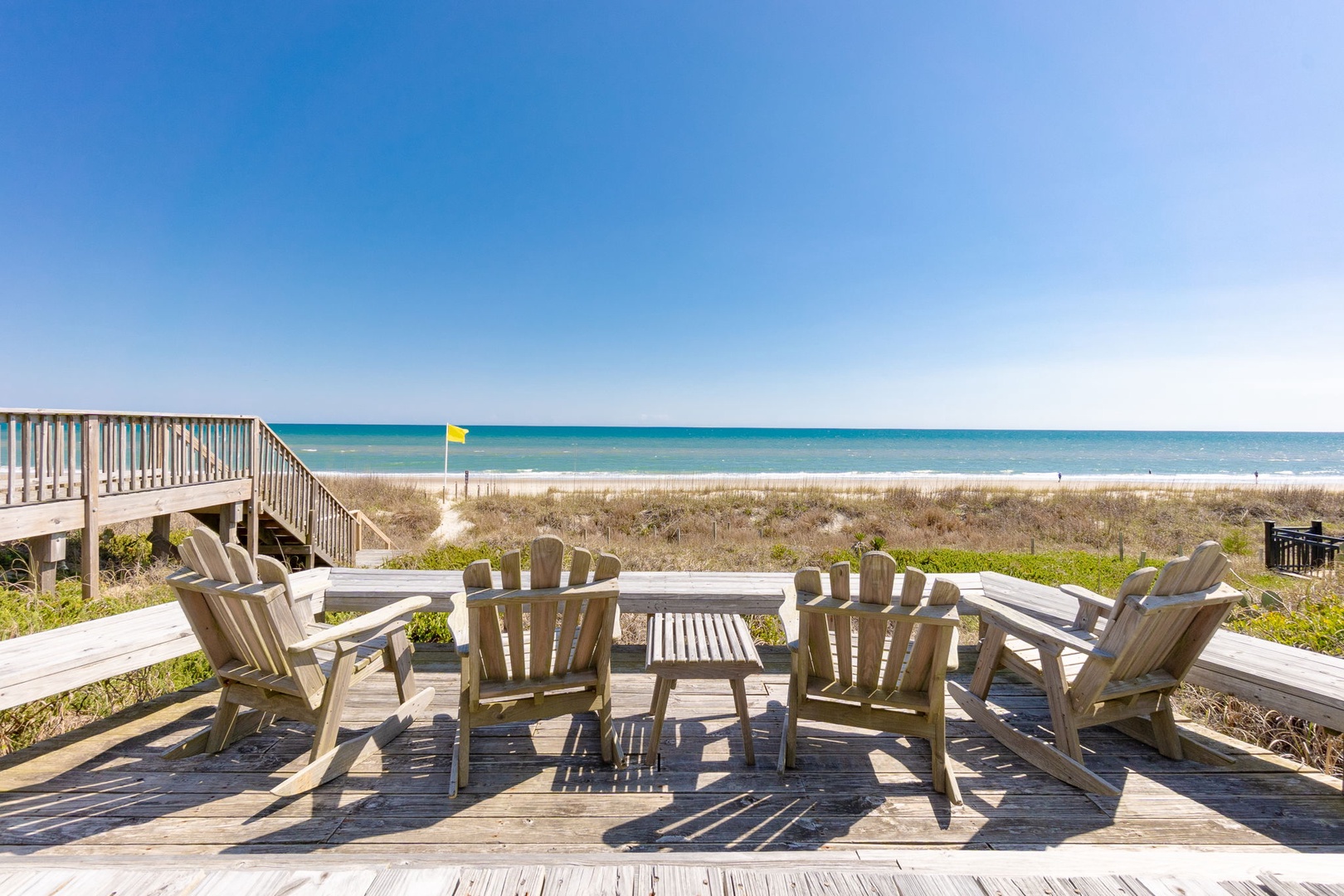 Relax in Adirondack chairs on your private deck with stunning ocean views and direct beach access.