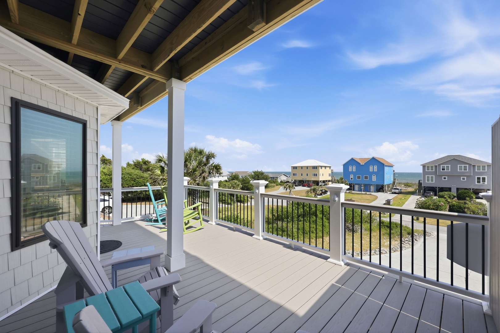 A coastal neighborhood with nearby beach houses frames this peaceful community setting, providing a glimpse of the surrounding area and ocean horizon.