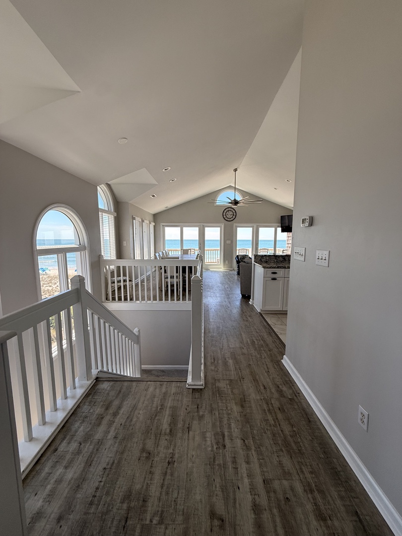 Relax in your inviting bedroom with modern wood-tone floors, a cozy bed, and bright windows that fill the space with natural light.