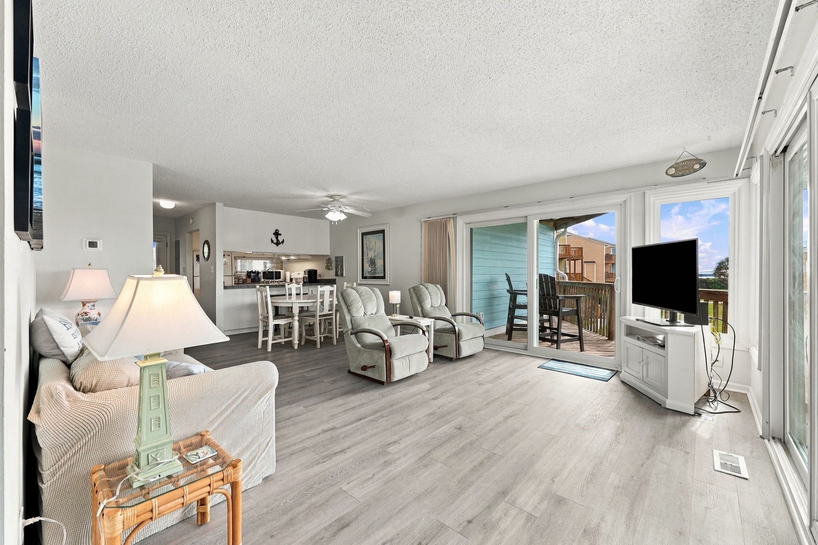 Settle into your spacious, light-filled living area where coastal charm meets relaxation. Slide open the glass doors to your private balcony and let the fresh air flow through as you unwind.