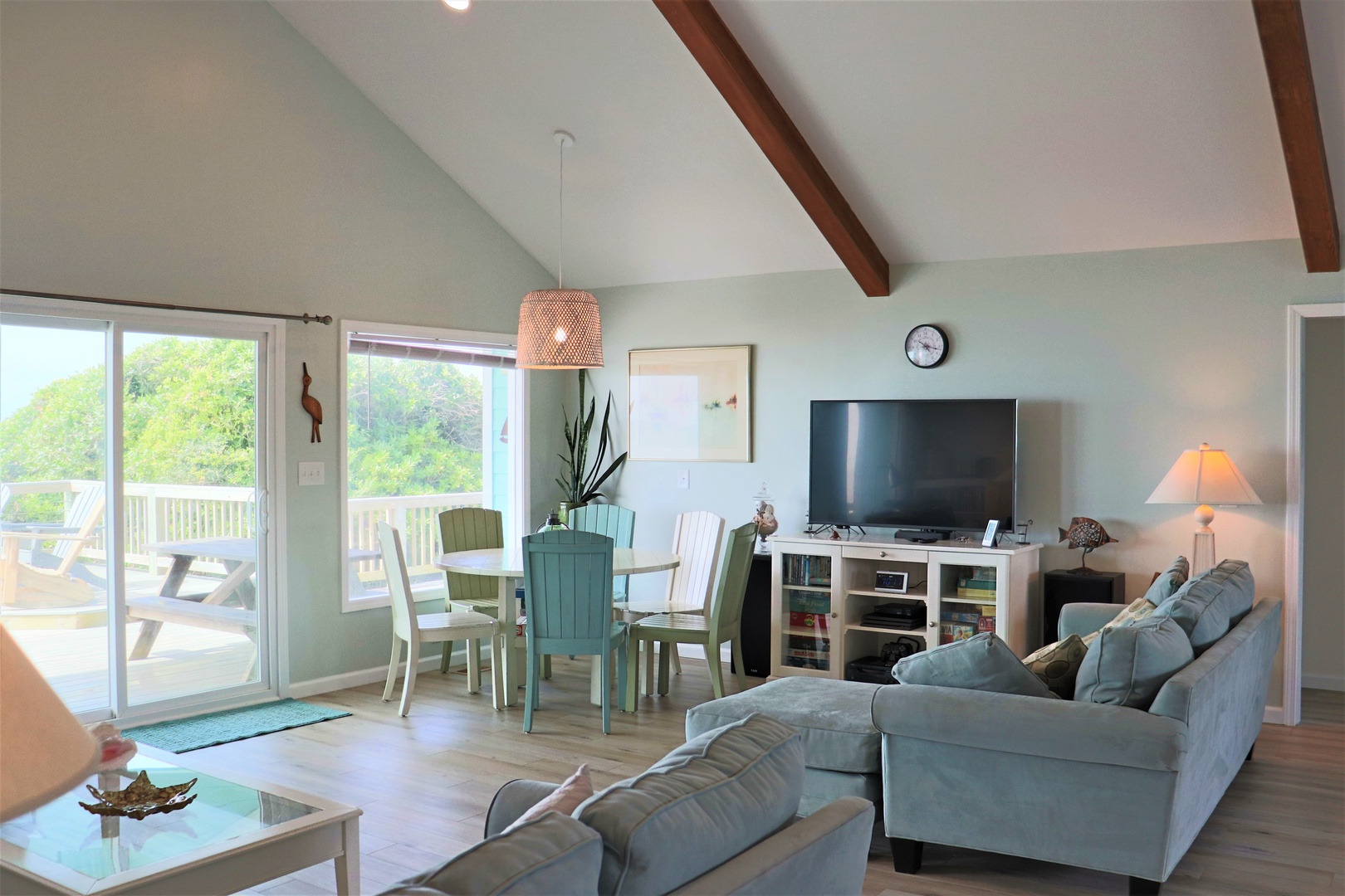 Unwind in your bright coastal living space with vaulted ceilings, cozy sectional seating, and sliding doors opening to your private deck.