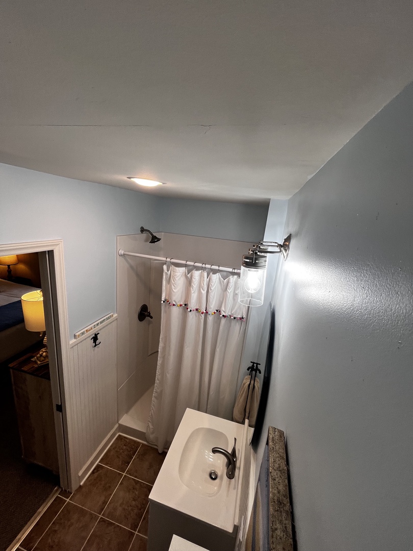 Your private bathroom features a spacious shower, sink, and toilet with warm lighting and modern finishes for your comfort.