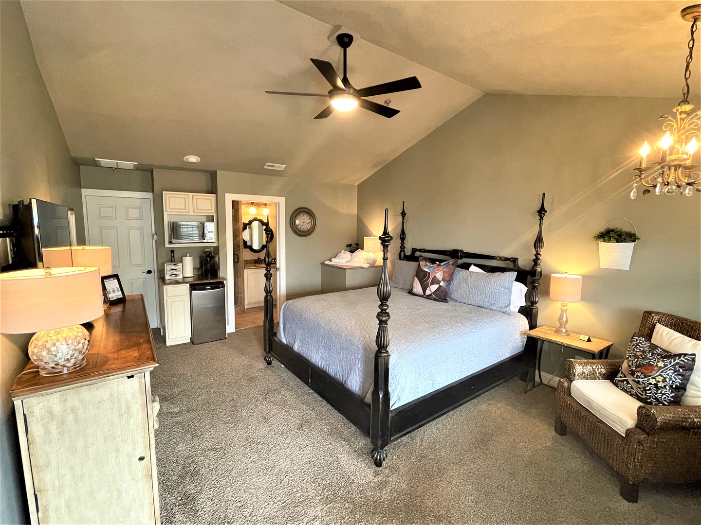 Unwind in your elegant bedroom featuring a grand four-poster bed, cozy seating, and convenient kitchenette for ultimate comfort.