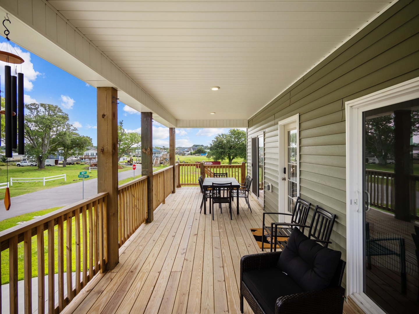 Your spacious covered deck offers the perfect spot to unwind with outdoor dining and comfortable seating overlooking peaceful green spaces.