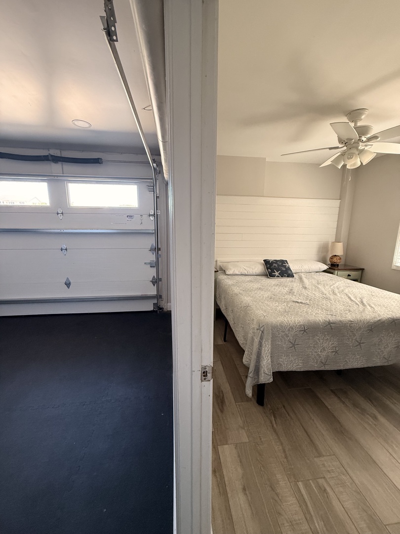A bright, open bedroom with a cozy bed tucked under a skylight. Soft natural light pours in, warming the wood-grain floors and neutral tones—perfect for restful mornings.