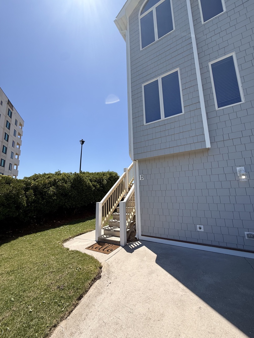 Modern townhome exterior featuring a private outdoor deck and small lawn area, situated in a well-maintained residential neighborhood with convenient street access.