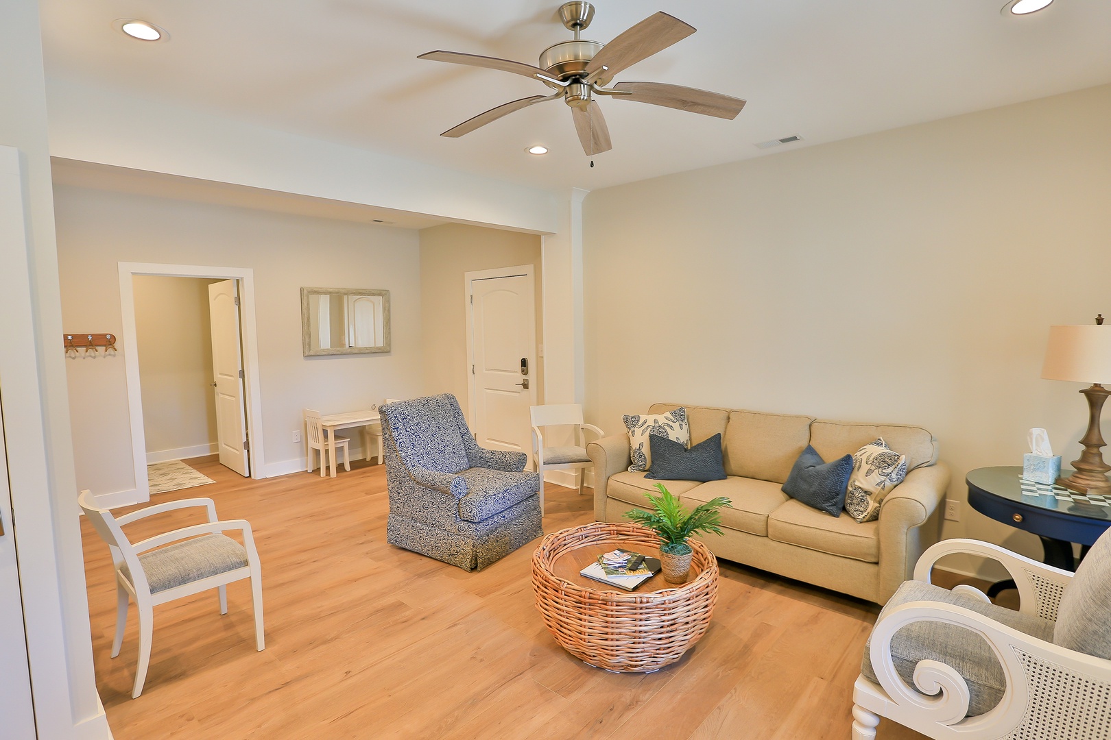 Relax in your spacious living room with comfortable seating, warm wood floors, and a ceiling fan to keep you cool.