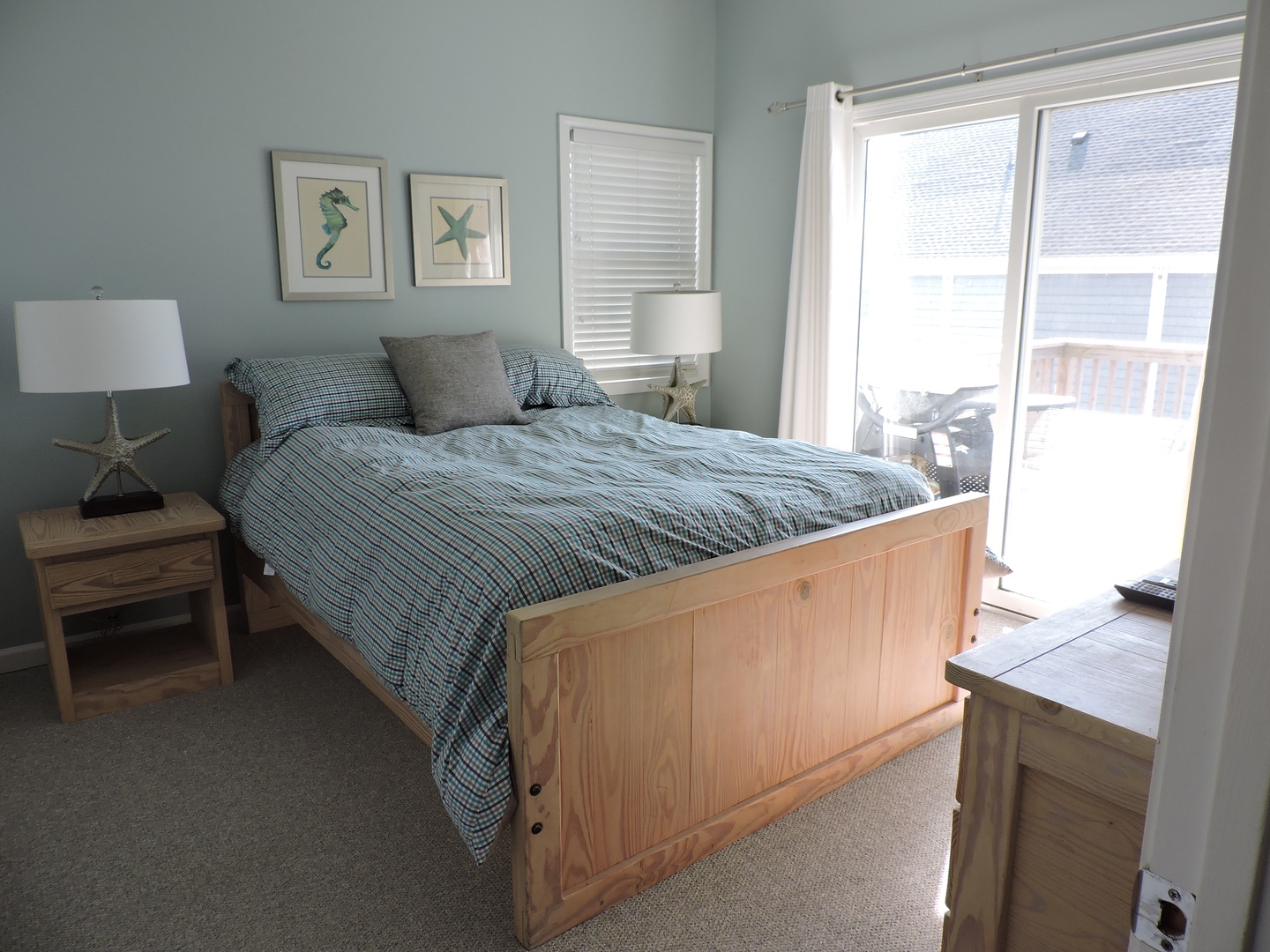 Wake up to gentle breezes in your coastal bedroom featuring a comfy wooden bed and soothing sea-inspired decor.