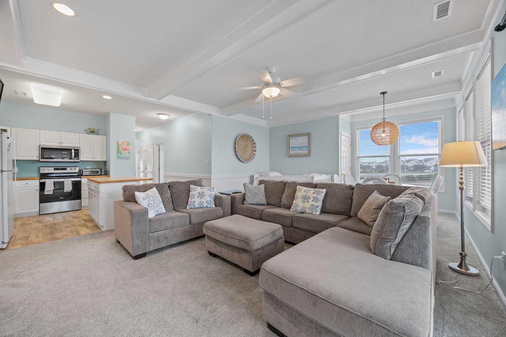 Sink into plush sectional seating where your group can unwind together, with an open kitchen perfect for preparing snacks and ocean views framing your relaxation.