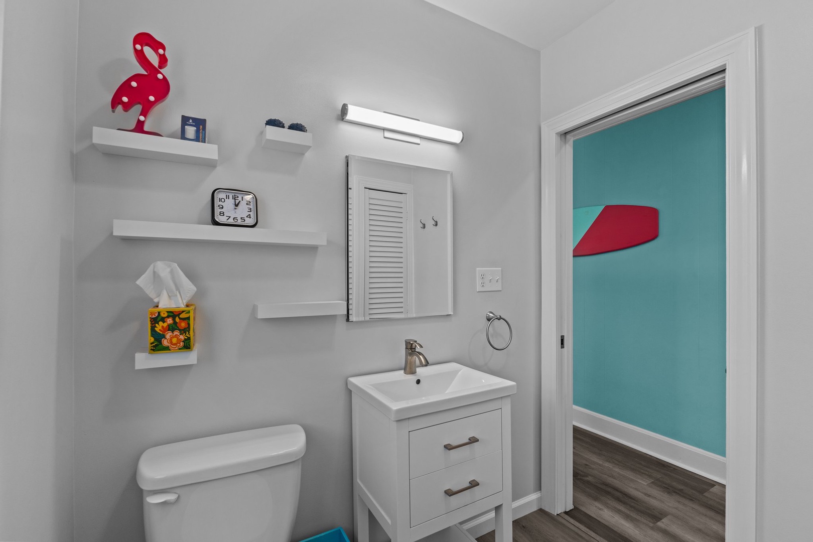 Your stylish bathroom features smart storage shelves and modern fixtures, with colorful accents creating a cheerful space for your morning routine.