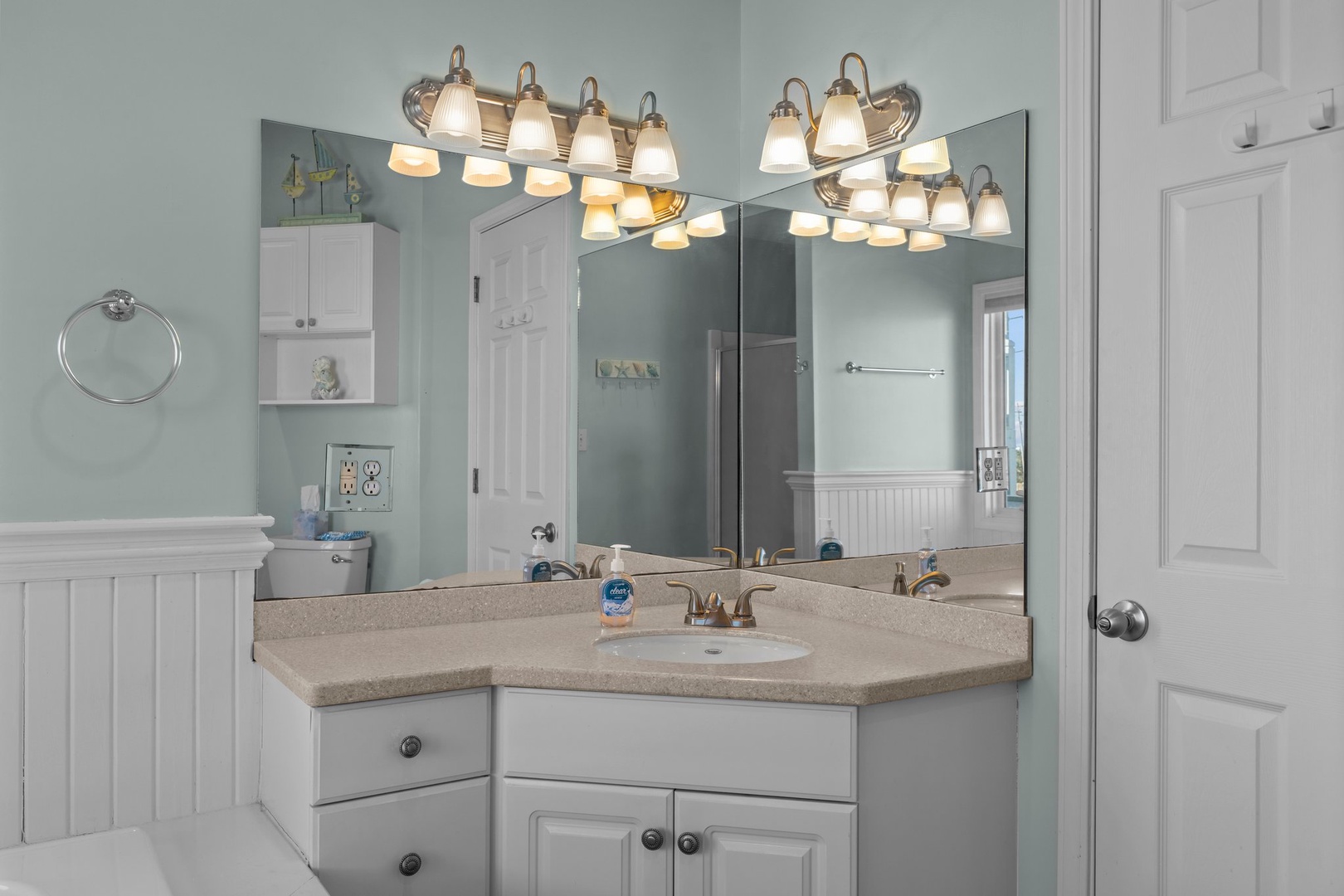 Your spacious bathroom features elegant lighting, ample storage, and warm coastal colors for your morning routines.