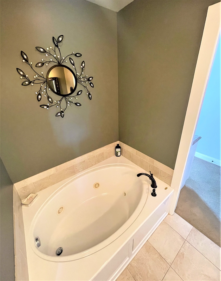Soak away your stress in this elegant jetted tub, complete with artistic mirror and soothing neutral tones.