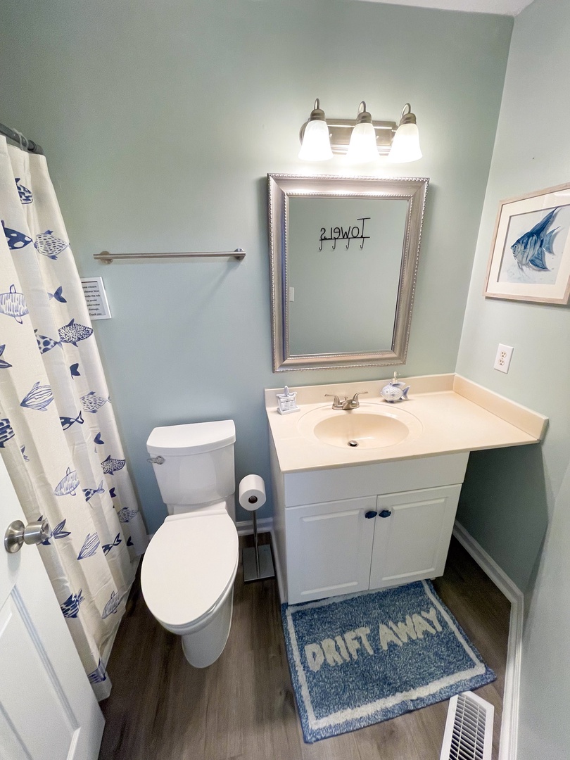 Step into your private coastal-themed bathroom with nautical touches, complete shower, and everything you need to refresh after beach adventures.