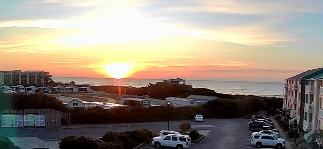 Stunning ocean sunset paints the sky in golden hues over this coastal community, creating a peaceful end to your beach day.