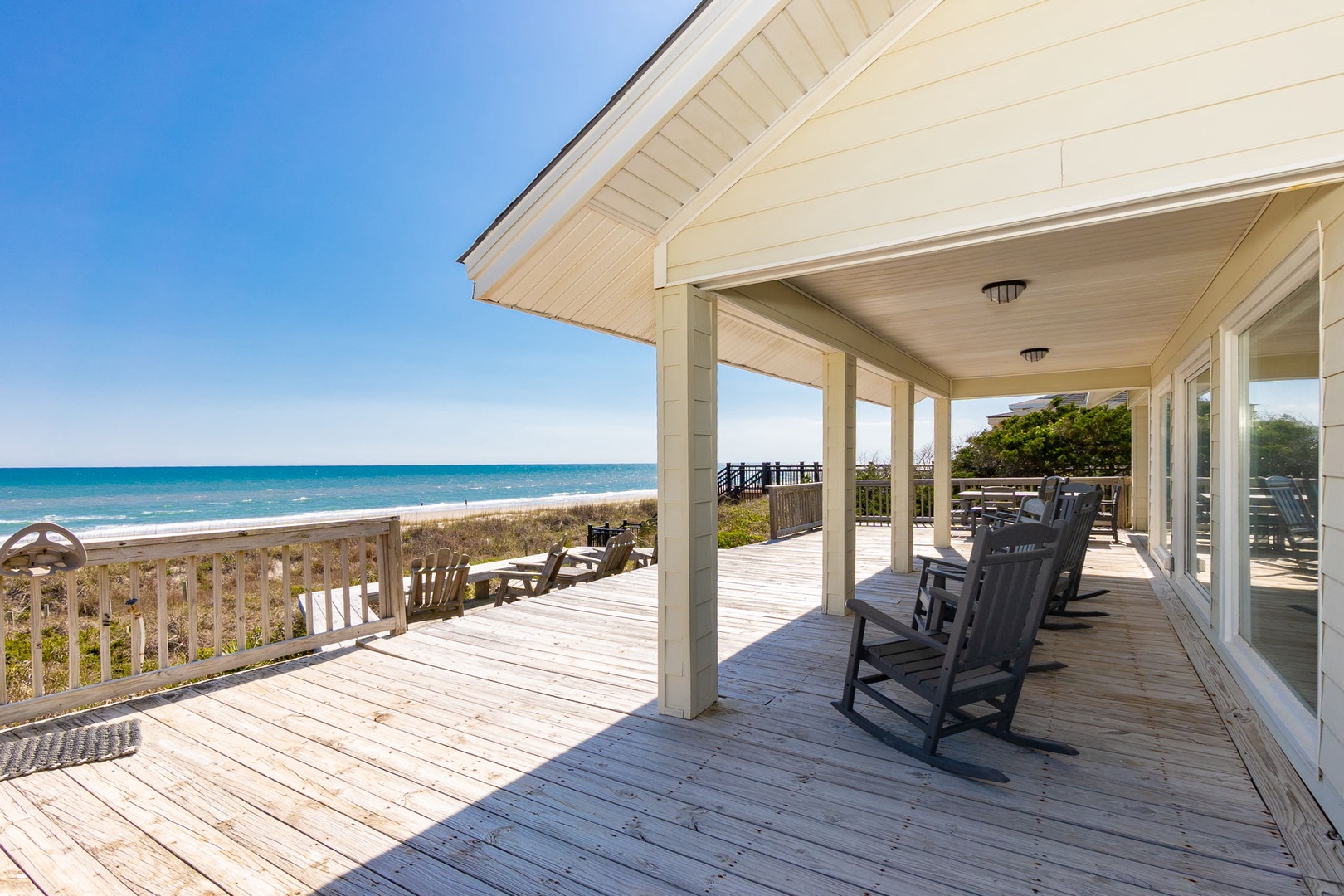 Relax in your rocking chairs on this wraparound deck, where ocean breezes and endless beach views create the perfect coastal retreat.