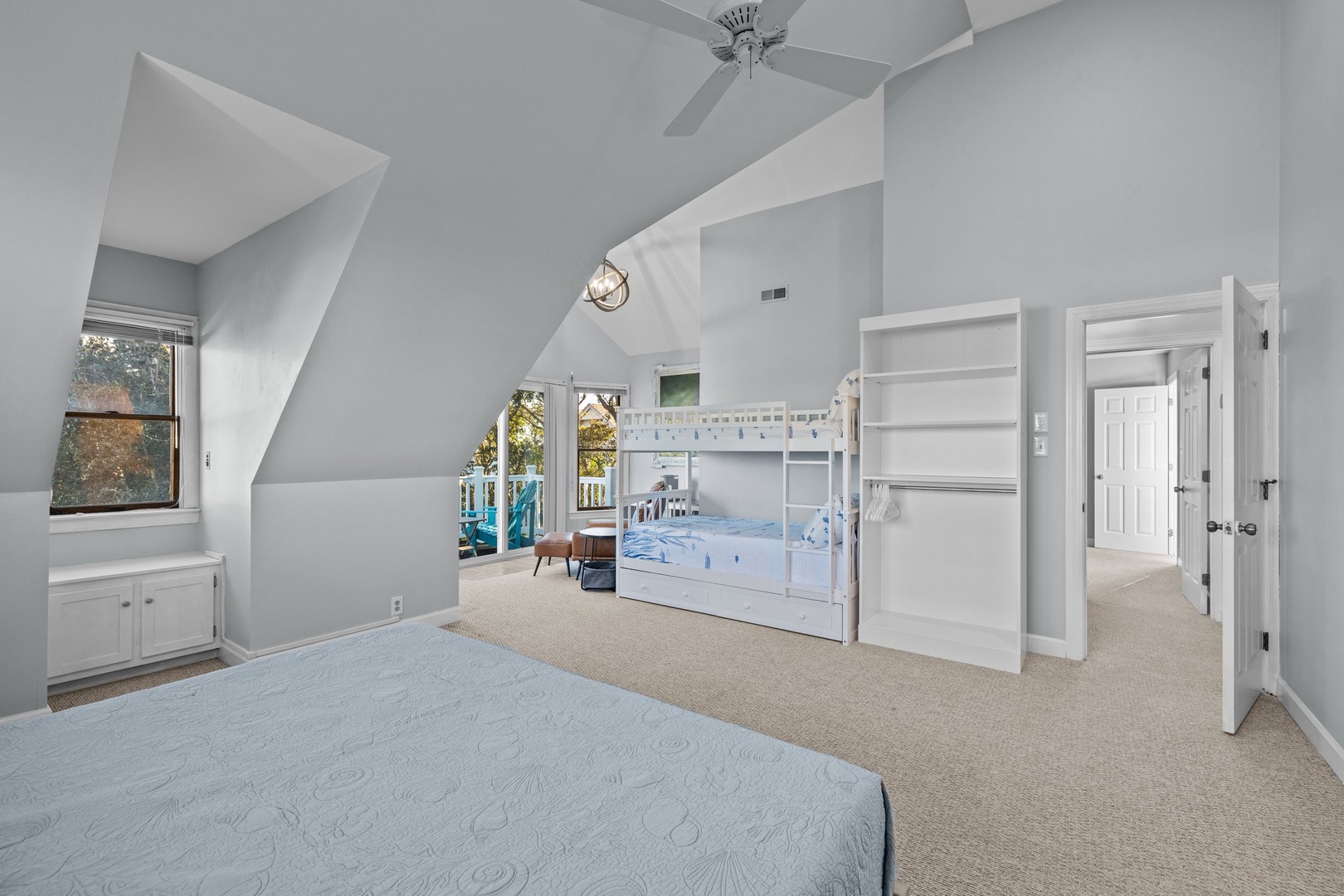 Your spacious bedroom features comfortable beds and charming bunk beds, perfect for families with high ceilings and natural light.