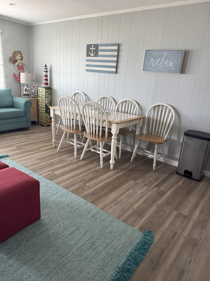 Gather around the charming coastal dining table where your group can enjoy meals together in this welcoming space.