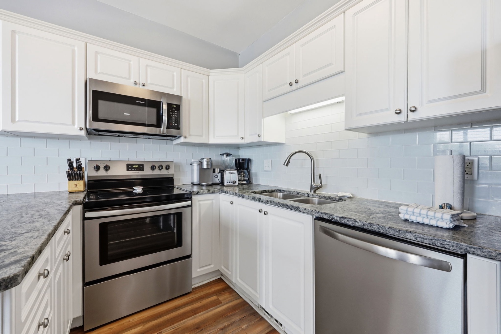 Your fully equipped kitchen awaits with stainless steel appliances, elegant granite counters, and crisp white cabinetry—perfect for preparing meals and enjoying your home away from home.