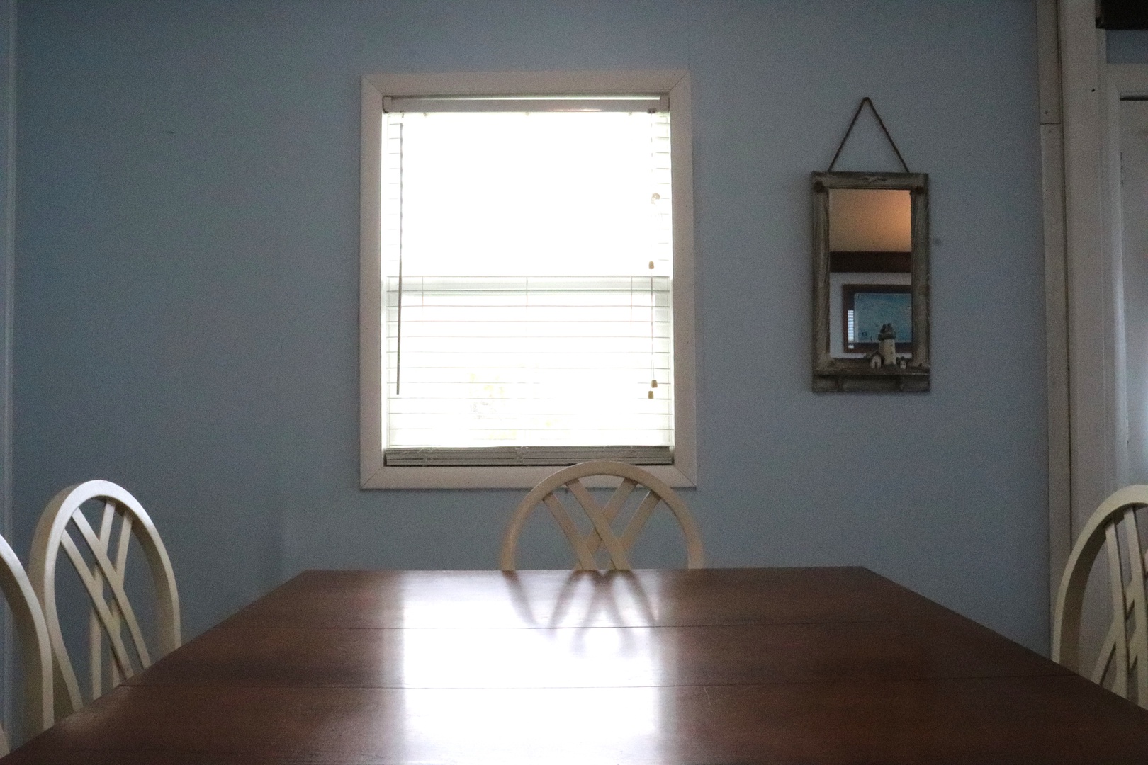 Gather around your spacious dining table, bathed in natural light from the window. The soothing blue walls create a calm atmosphere perfect for meals and conversation.