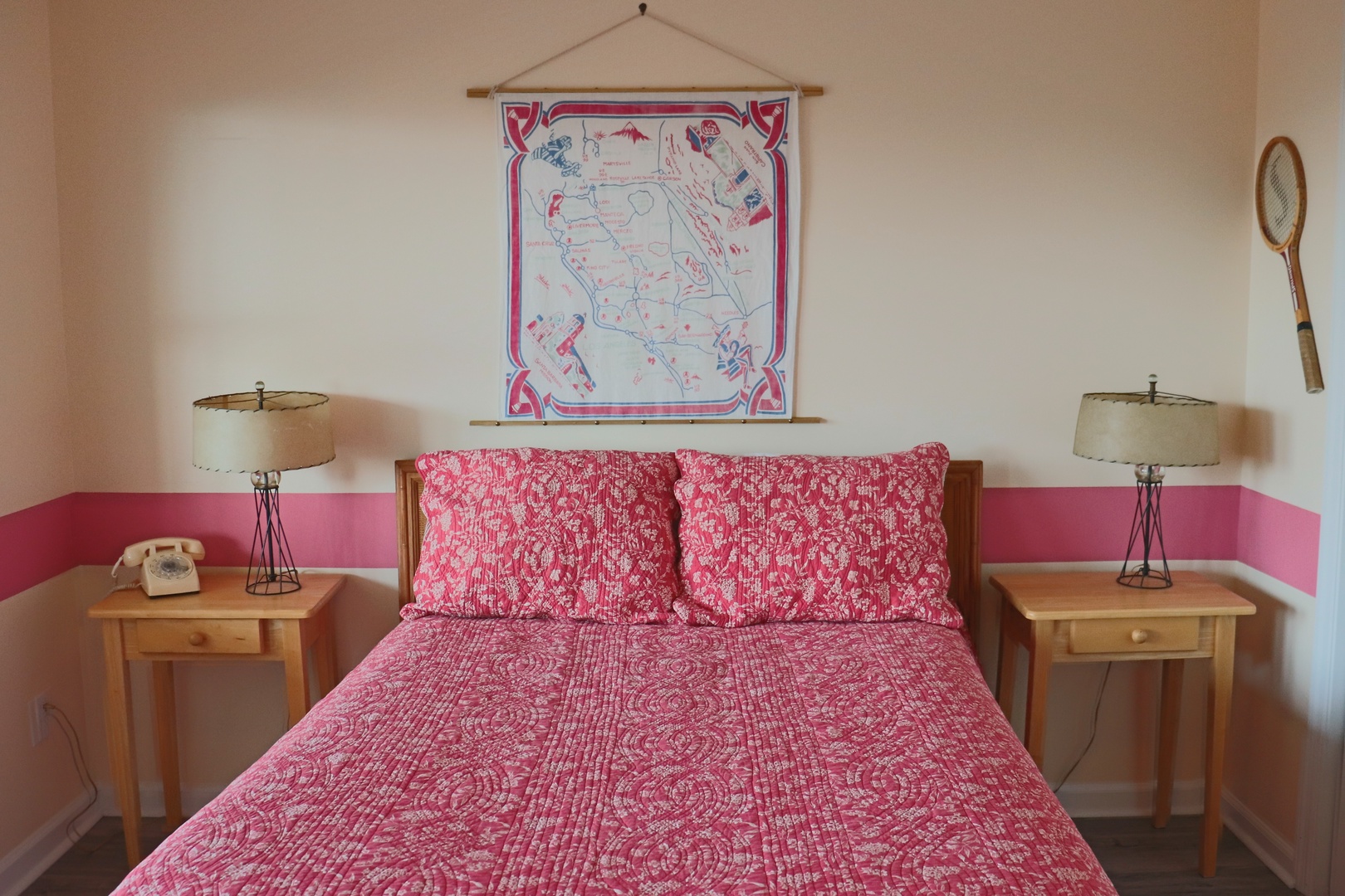 Rest in your charming bedroom with vintage touches, cozy red linens, and thoughtful details like bedside lamps and retro phone.