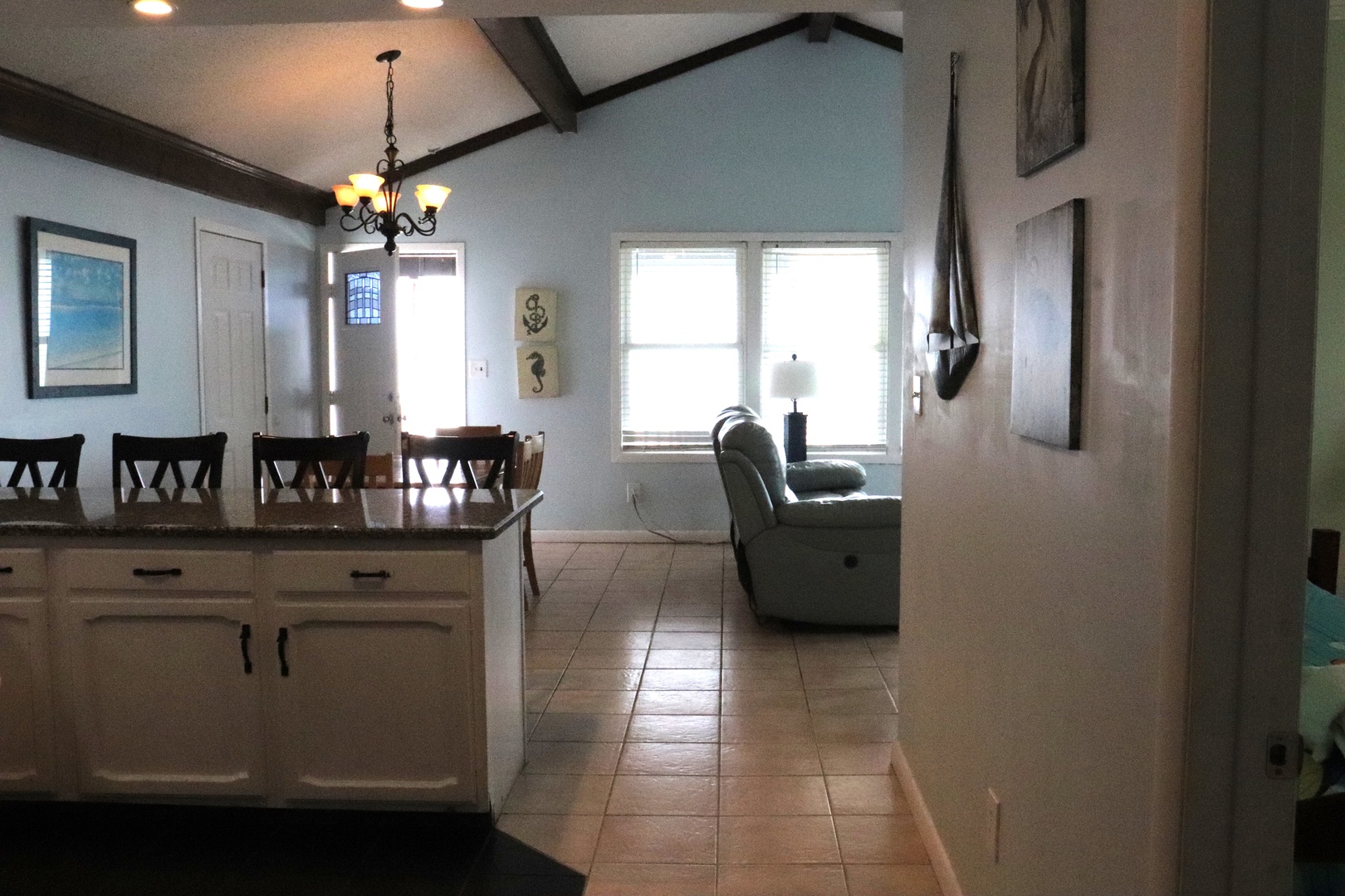 A bright, airy open-plan space flows effortlessly from dining to living areas. Natural light pours through large windows, illuminating nautical touches and comfortable furnishings where you'll gather and unwind.