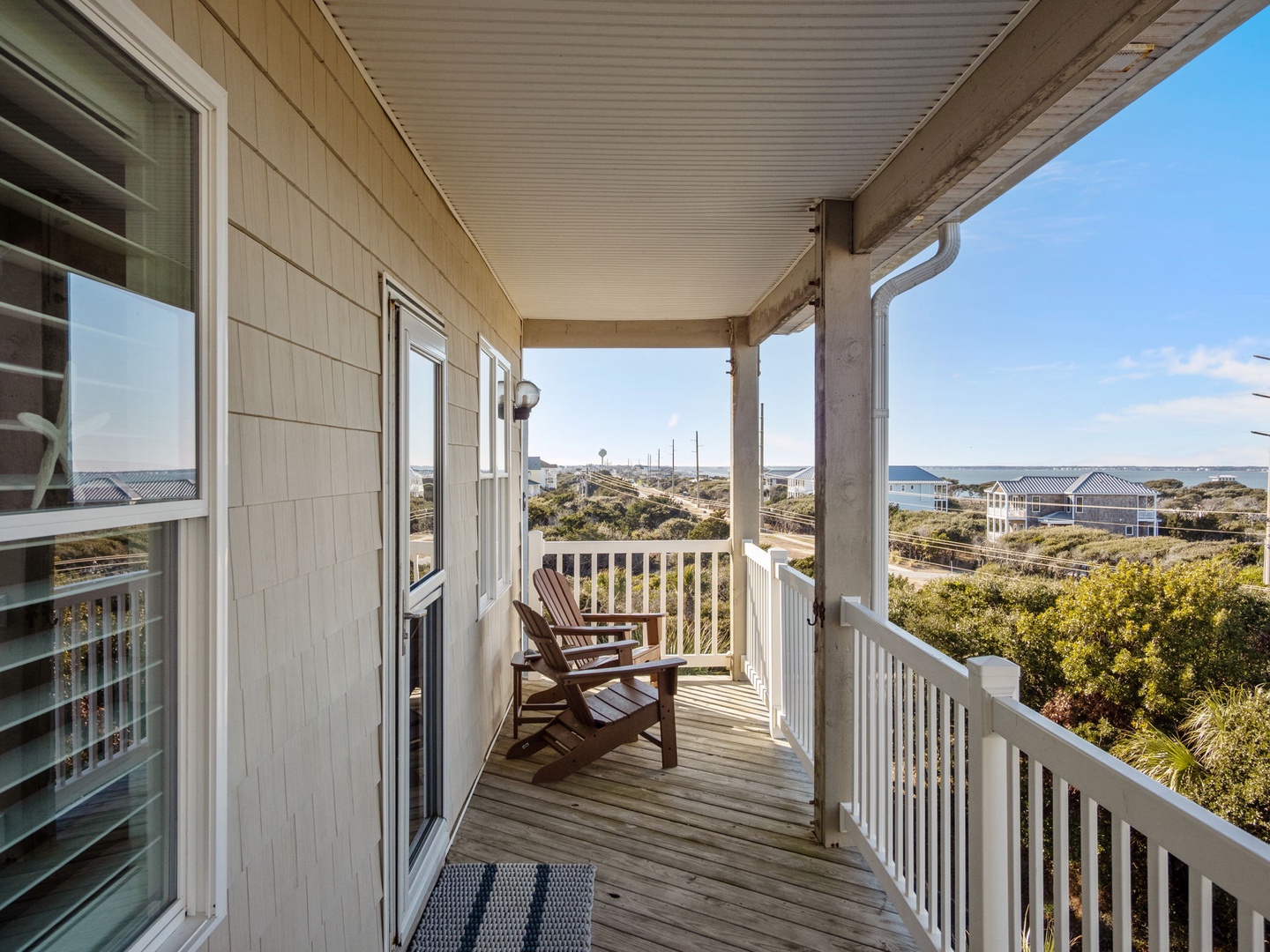Relax in your wooden Adirondack chairs on this peaceful covered porch, where ocean breezes and coastal views create your perfect morning coffee retreat.