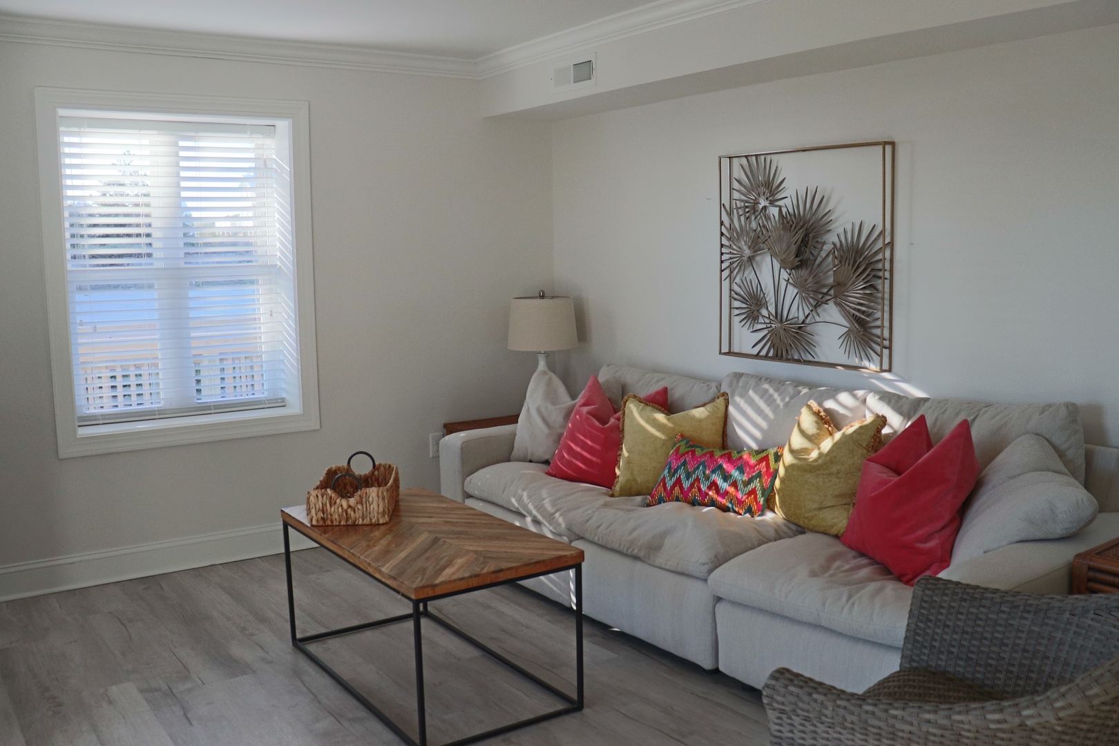 Sink into this plush sectional with colorful pillows and enjoy natural light streaming through your window blinds.