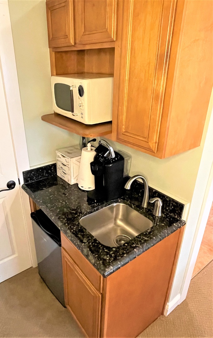 Your compact kitchenette features granite counters, stainless sink, microwave, and coffee maker—everything you need for convenient in-room dining.